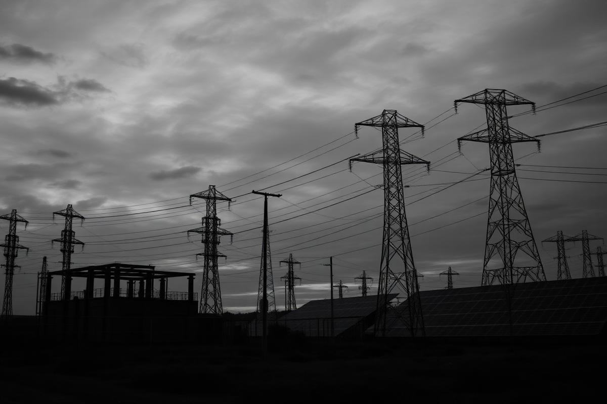 Umspannwerk und Strommasten neben einem Solarpark in der Dämmerung